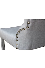 Upholstered dining chair features a classic nail head trim alongside back