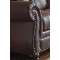 Shaped Rolled Arms with Nailhead Trim. Turned Wood Feet.