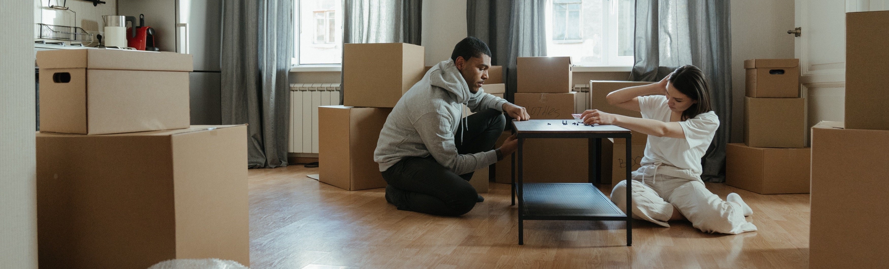 Two people assembling a new end table.