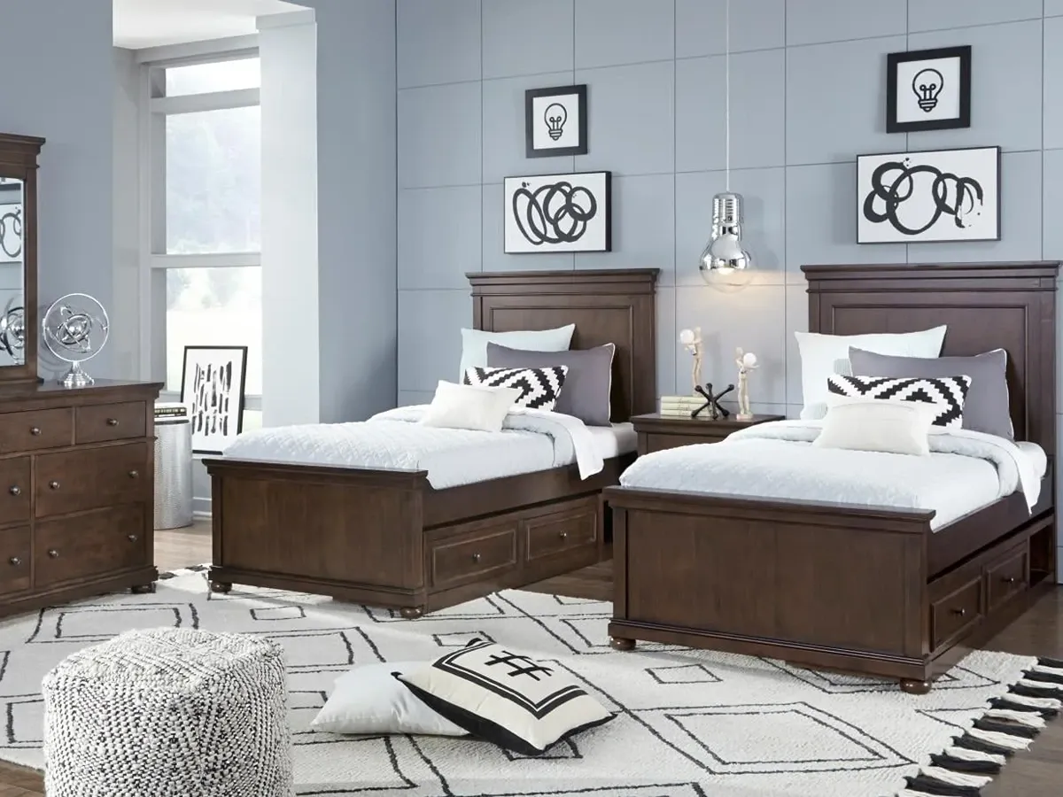 two dark wood toned twin beds with a matching dresser and mirror