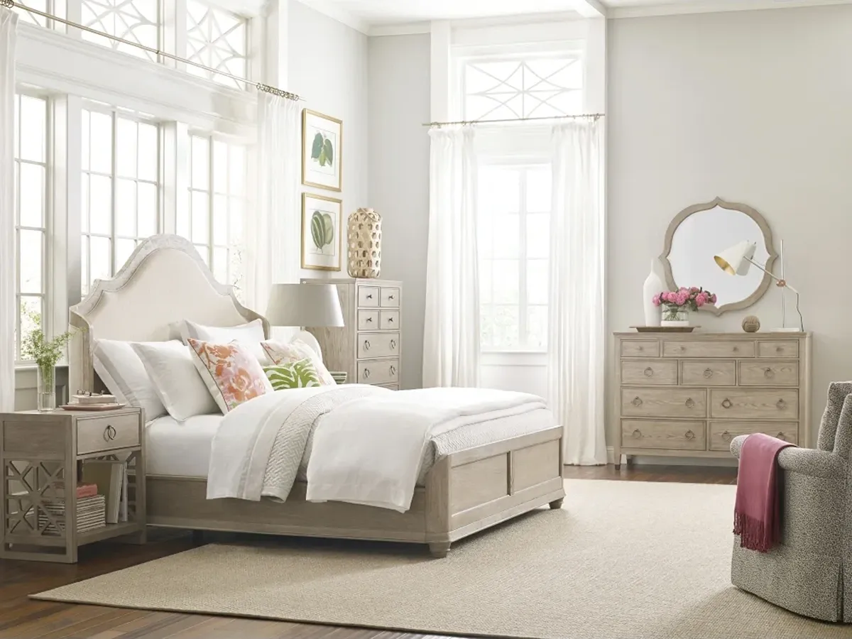 arch light wood tone bed with an upholstered headboard and matching nightstand, dresser and mirror