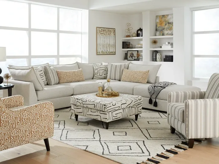 cream l-shaped sectional sofa with various throw pillows, striped arm chair and patterned orange arm chair