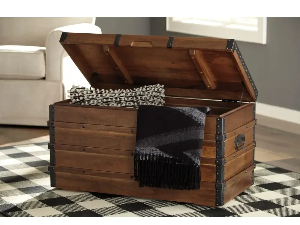Wooden chest cracked open to show blanket and pillow storage