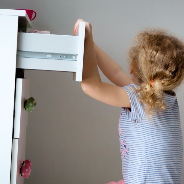 Young Girl pulling on dresser