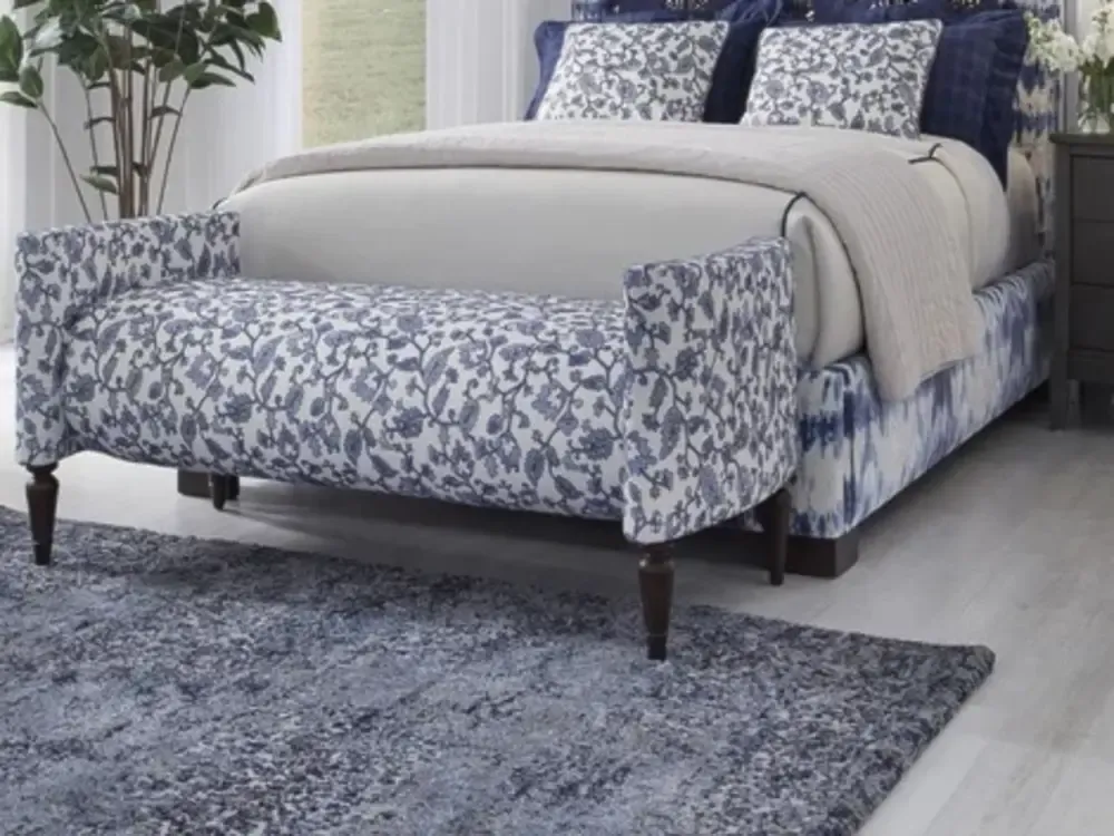 Made up bed with wood and fabric bench at the foot