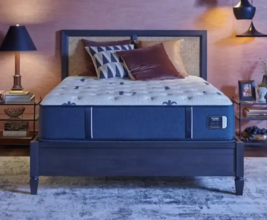 Finished bedroom with wooden bedframe and throw pillows.