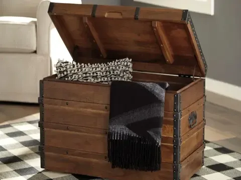 Wooden chest cracked open to show blanket and pillow storage