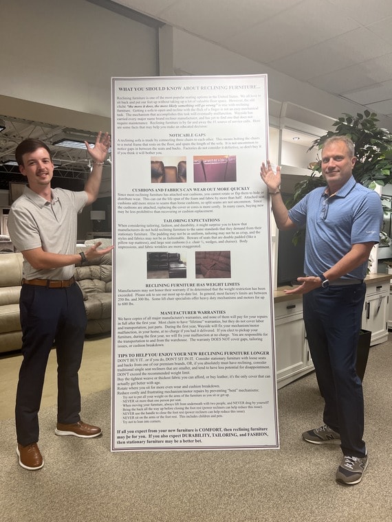 Salesman standing next to large sign with information about recliners