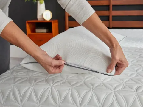 Mattress protector on unmade bed with a pillow