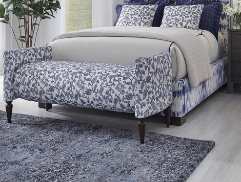 Made up bed with wood and fabric bench at the foot