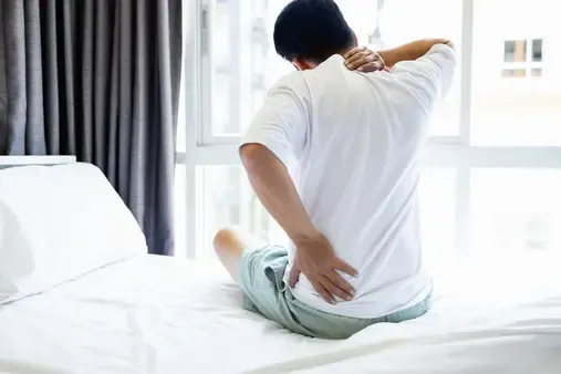 Person with aching back on mattress