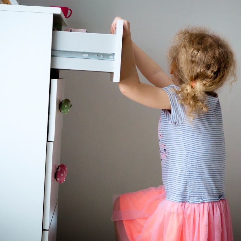 Young Girl pulling on dresser