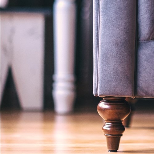 close up of wood sofa leg on grey sofa