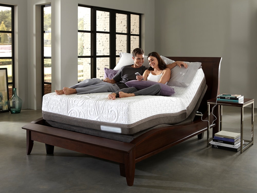 man and woman laying on mattress on an adjustable base