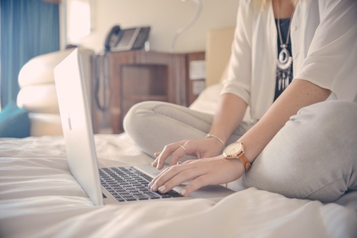 woman working on laptop in bed