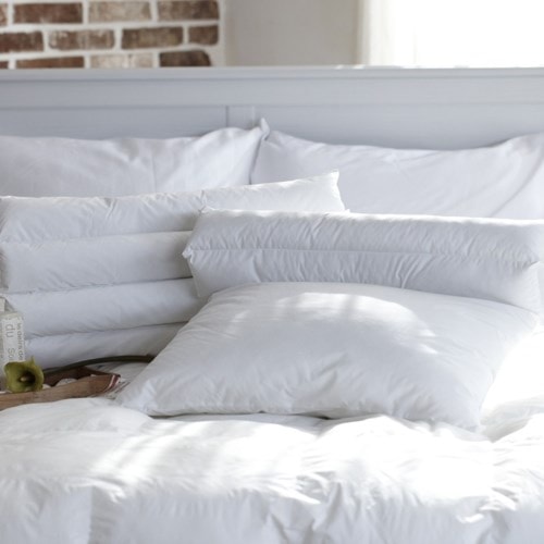 a bunch of white pillows on a white blanket