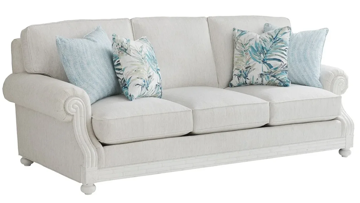 Off-white fabric sofa with four throw pillows. 