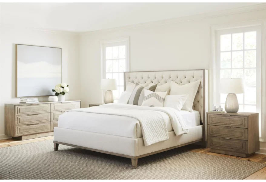 A tasteful modern bedroom filled with Michael Weiss furniture and featuring a cream-colored bed with a padded headboard. 