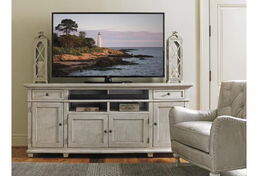 A light-colored wood TV console with open storage and cabinets. 