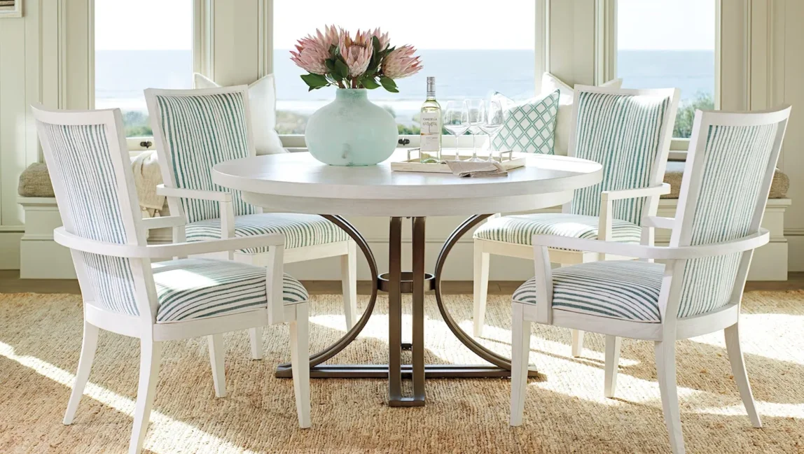 Small white dining table with four coastal armchairs around it. 