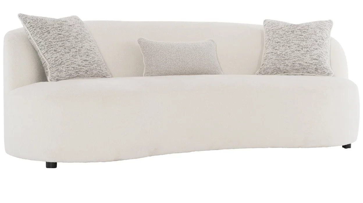 White plush sofa without arms and with off-white throw pillows. 