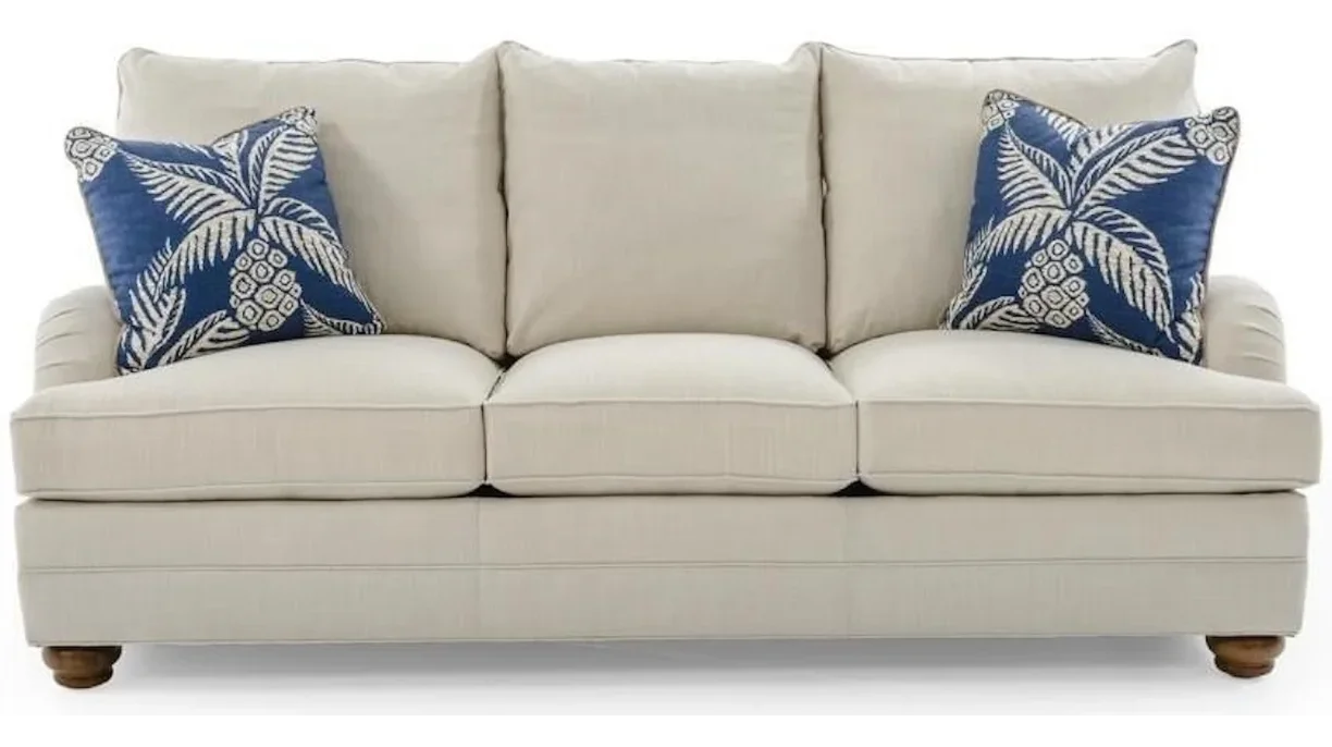 Stunning fabric sofa with two blue tropical throw pillows.