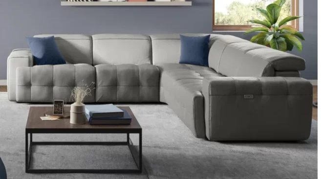 Gray sectional with blue throw pillows. 